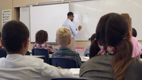 5th-grade-math-class-watches-teacher,-back-view,-shot-on-R3D