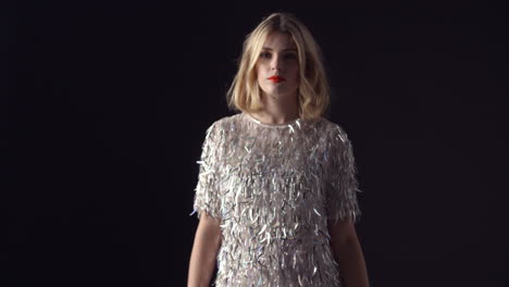 Blonde-woman-in-sparkly-dress-walking-to-camera,-into-focus