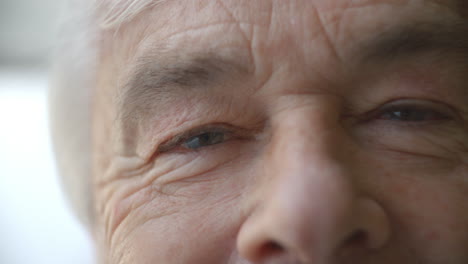 Close-up-of-Senior-Man's-face-blinking-and-smiling