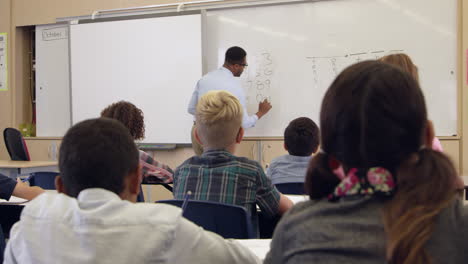 Teacher-taking-5th-grade-maths-class,-back-view,-shot-on-R3D