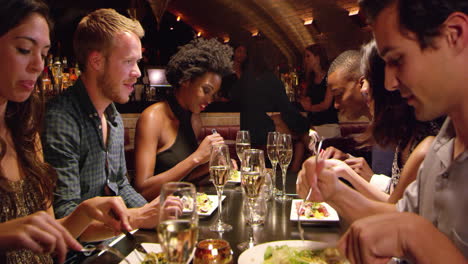 Group-Of-Friends-Enjoying-Meal-In-Restaurant-Shot-On-R3D
