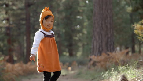 Asiatisches-Kleinkindmädchen-Spielt-Mit-Tannenzapfen-In-Einem-Wald,-Aus-Nächster-Nähe