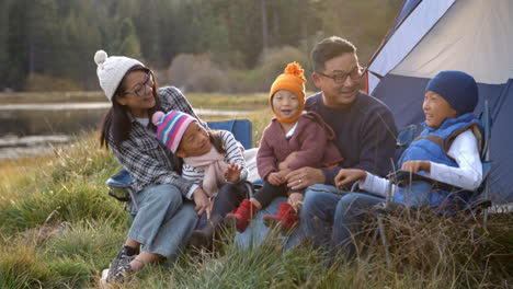 Asiatische-Familie-Auf-Einem-Campingausflug,-Die-Sich-Vor-Ihrem-Zelt-Entspannt
