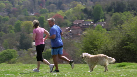 Mature-Couple-With-Dog-Jogging-In-Countryside-Shot-On-R3D