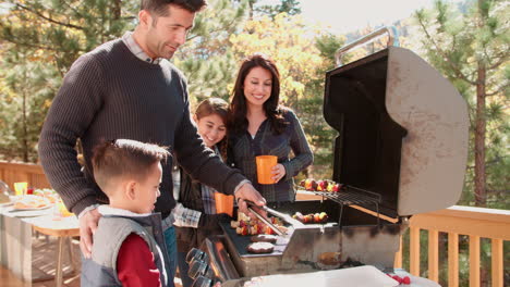 Family-barbecuing-on-a-deck-in-the-forest