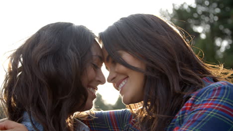 Lesbian-couple-embrace-touching-noses,-eyes-closed,-close-up