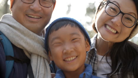 Handheld-close-up-of-Asian-family-of-four-in-a-forest