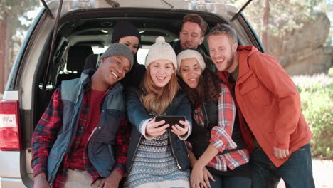 Group-of-six-friends-take-a-selfie-in-an-open-car-hatchback