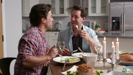 Male-gay-couple-having-a-candlelit-dinner-in-their-kitchen,-shot-on-R3D