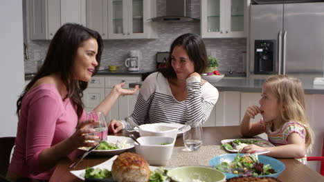 Lesbisches-Paar-Und-Tochter-Beim-Abendessen-In-Ihrer-Küche,-Aufgenommen-Auf-R3D