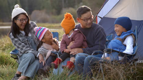Asiatische-Familie-Auf-Einem-Campingausflug,-Die-Sich-Vor-Ihrem-Zelt-Unterhält