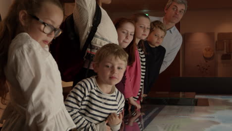 Pupils-On-School-Trip-To-Museum-Looking-At-Map-Shot-On-R3D