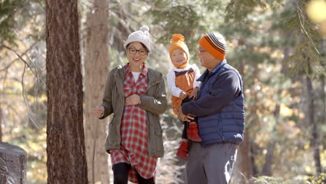 Pregnant-Asian-mother,-husband-and-daughter-hiking-in-forest