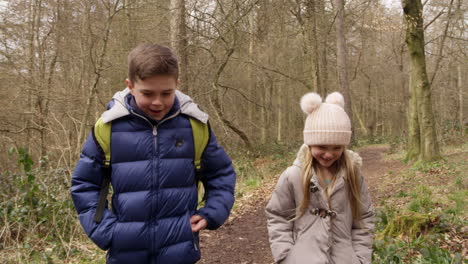 Two-kids-walking-in-woods-towards-tracking-handheld-camera,-shot-on-R3D
