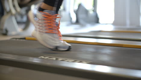 Feet-of-a-woman-on-a-running-machine-at-a-gym,-close-up