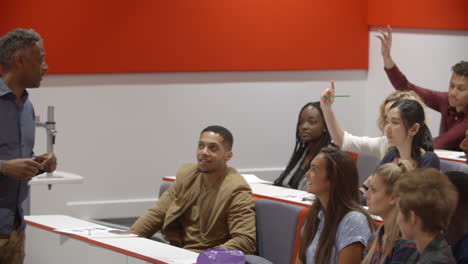 Male-teacher-with-university-students-in-lecture-theatre