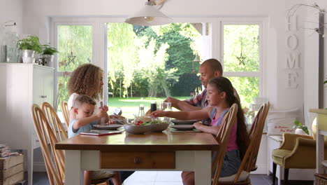 Family-At-Home-Eating-Meal-In-Dining-Room-Together