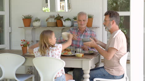 Gleichgeschlechtliche-Familie-Zu-Hause-Beim-Essen-Auf-Der-Veranda-Im-Freien