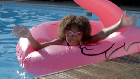 Girl-Having-Fun-With-Inflatable-In-Outdoor-Swimming-Pool