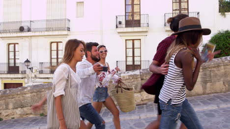 Young-adult-friends-walking-in-Ibiza,-Spain,-tracking-shot,-shot-on-R3D