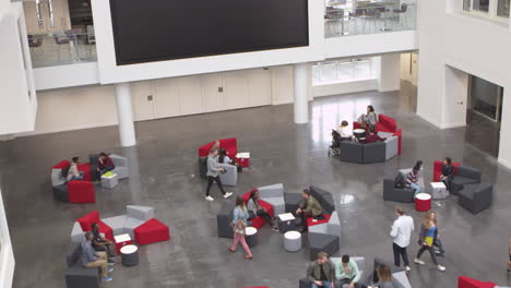 Overhead-handheld-tilt-shot-of-university-atrium-and-busy-lobby,-shot-on-R3D