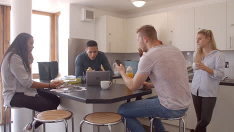 Students-Relaxing-In-Kitchen-Of-Shared-Accommodation