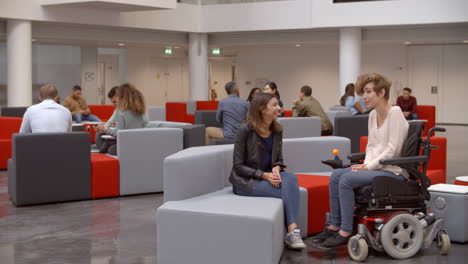 Students-talking-in-a-meeting-area-in-a-university-lobby
