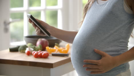 Schwangere-Frau-Befolgt-Rezept-Auf-Digitalem-Tablet,-Aufgenommen-Auf-R3D