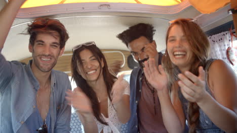 Four-excited-adult-friends-on-a-road-trip-in-a-camper-van