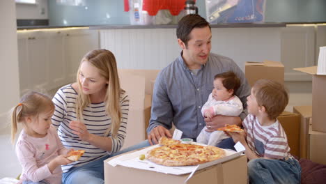 Familie-Feiert-Einzug-In-Neues-Zuhause-Mit-Pizza