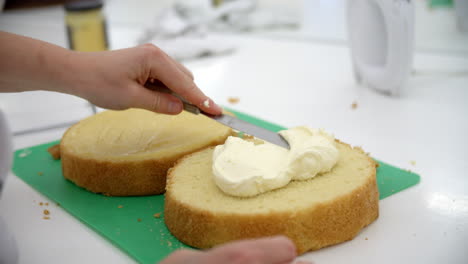Frau-In-Bäckerei-Verteilt-Füllung-Für-Kuchen-Mit-Messer