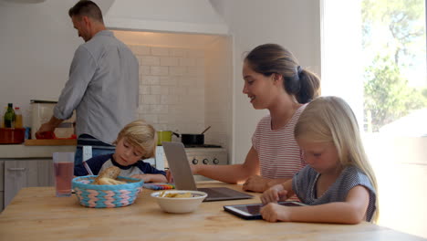 Kids-at-kitchen-table-with-mum-while-dad-cooks