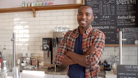 Business-owner-crosses-arms-at-the-counter-of-coffee-shop