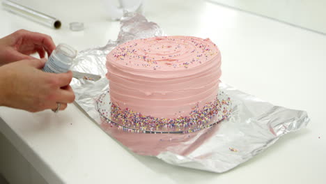 Woman-In-Bakery-Decorating-Cake-With-Sugar-Sprinkles
