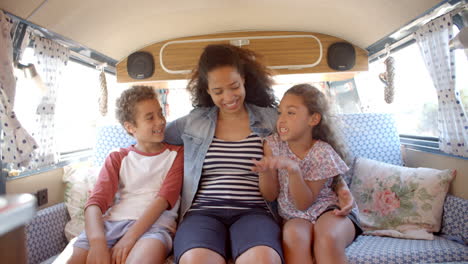 Lächelnde-Mutter-Und-Kinder,-Die-Auf-Der-Rückseite-Eines-Wohnmobils-Unterwegs-Sind