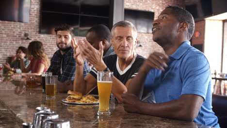 Group-Of-Male-Friends-Watching-Game-In-Sports-Bar