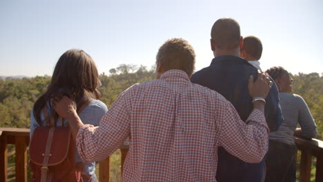 Multi-generation-family-admiring-view-from-deck,-back-view
