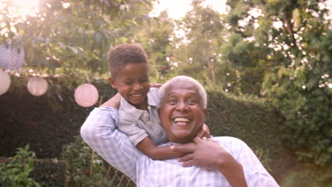 Young-black-boy-playing-with-grandad-in-the-garden,-close-up