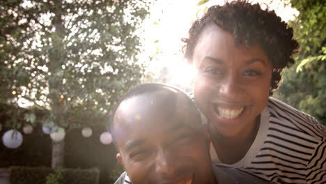 Happy-mixed-race-couple-piggybacking-in-garden,-close-up