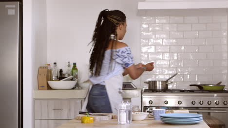 Vista-Frontal-De-Una-Mujer-Cortando-Y-Cocinando-Ingredientes-En-Casa,-Filmada-En-R3d