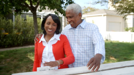 Senior-black-couple-walk-into-focus-outside-their-home