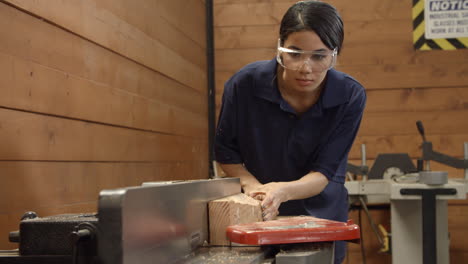 Female-Carpenter-Using-Plane-In-Woodworking-Woodshop