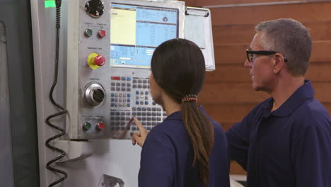 Ingenieur-Schult-Weibliche-Lehrlinge-Auf-Einer-CNC-Maschine,-Aufgenommen-Auf-R3D