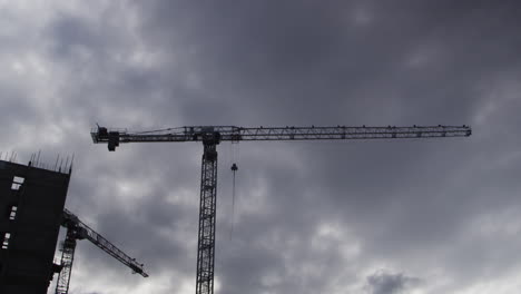 Silhouette-Of-Tower-Cranes-On-Construction-Site