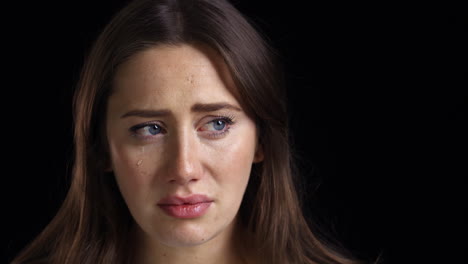 Studio-Shot-Of-Unhappy-Young-Woman-Crying-Into-Camera