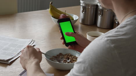 Mann,-Der-Smartphone-Mit-Grünem-Bildschirm-Benutzt-Und-Frühstückt