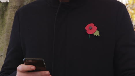 Man-Wearing-Remembrance-Day-Poppy-Using-Mobile-Phone