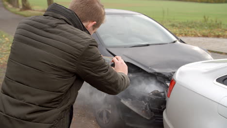 Man-Taking-Photo-Of-Car-Accident-On-Mobile-Phone