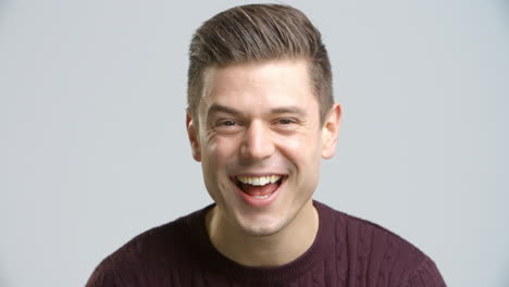 Studio-Shot-Of-Young-Man-Smiling-Into-Camera-In-Slow-Motion
