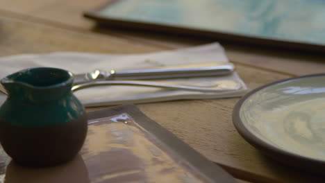 Handmade-earthenware-on-table,-close-up-camera-slider-shot